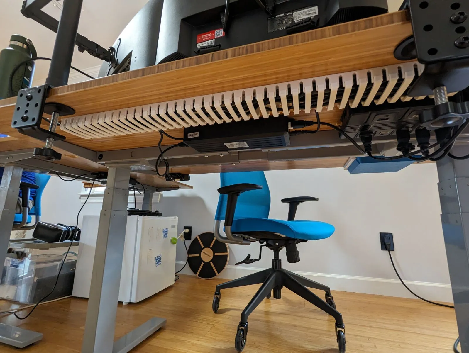 Hệ khay quản lý dây cáp dạng modular gắn dưới mặt bàn, giúp giấu và sắp xếp dây nguồn chuyên nghiệp