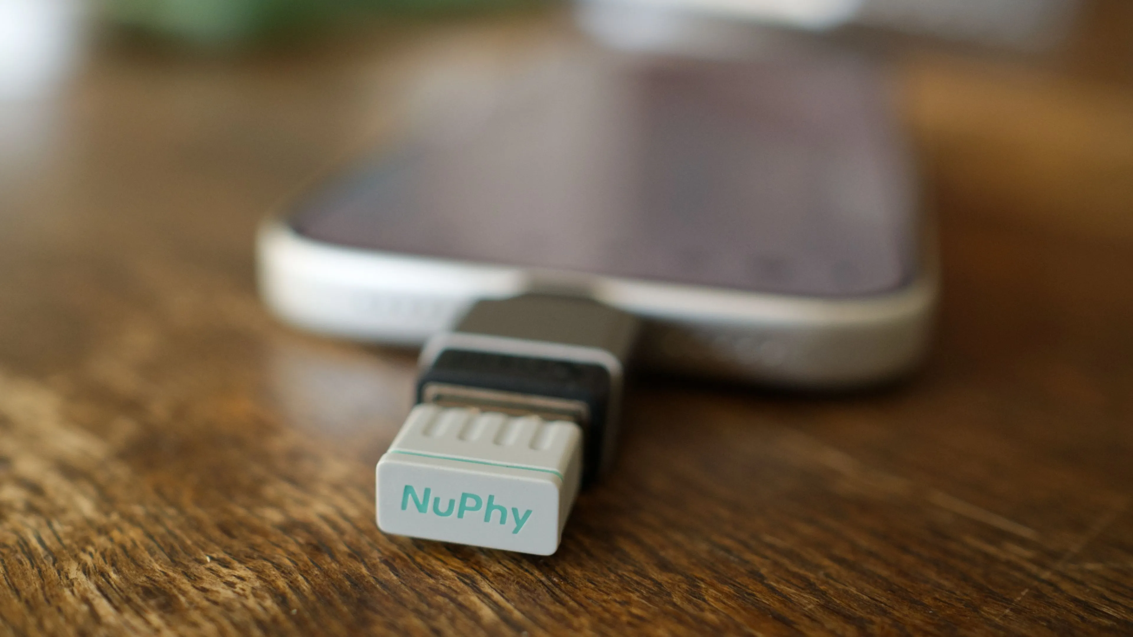 iPhone 17 Pro đặt cạnh bàn phím cơ với dongle 2.4GHz của NuPhy, cho thấy khả năng tương thích bất ngờ.