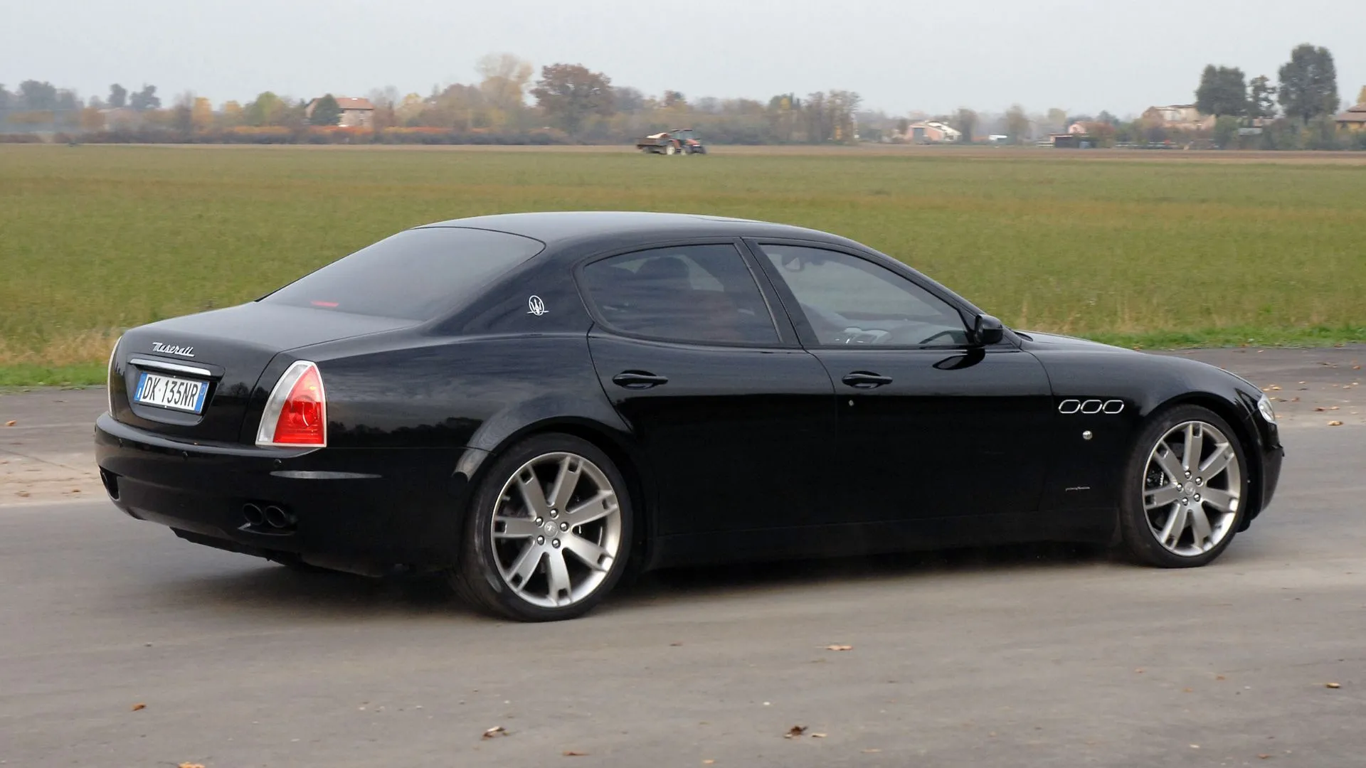 Maserati Quattroporte (2007) - góc sau 3/4 màu đen, ví dụ xe giá rẻ vẫn có ngoại hình đậm chất Ý.