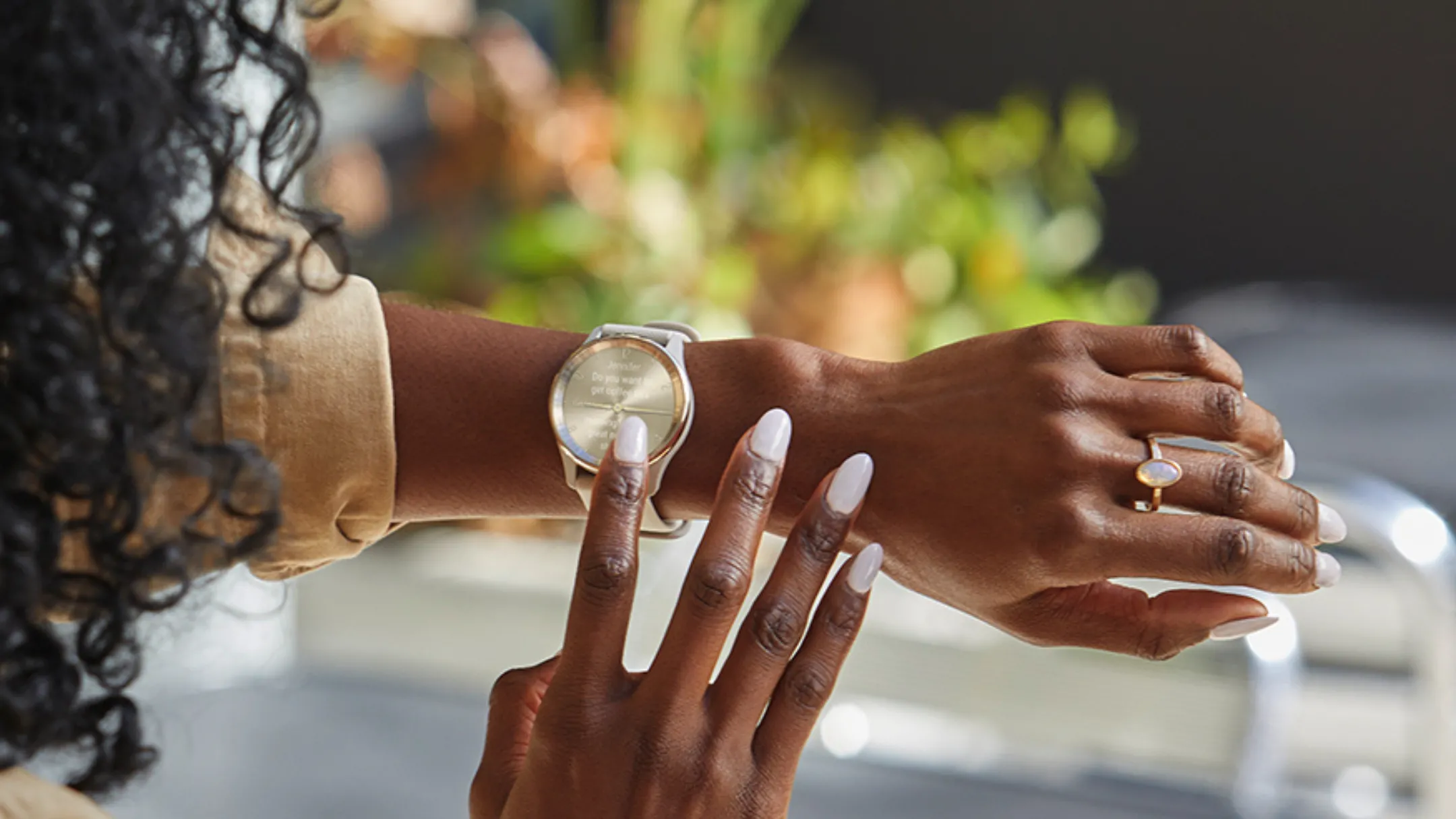 Người chạm vào núm đồng hồ của Garmin Vivomove Trend, thể hiện thiết kế tối giản và dạng hybrid.