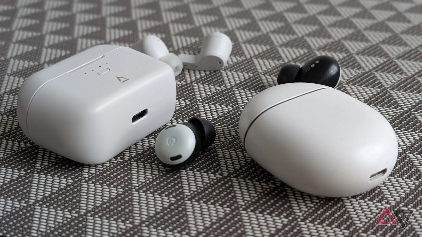 Pixel Buds trắng bên cạnh tai nghe Creative trên nền đen trắng