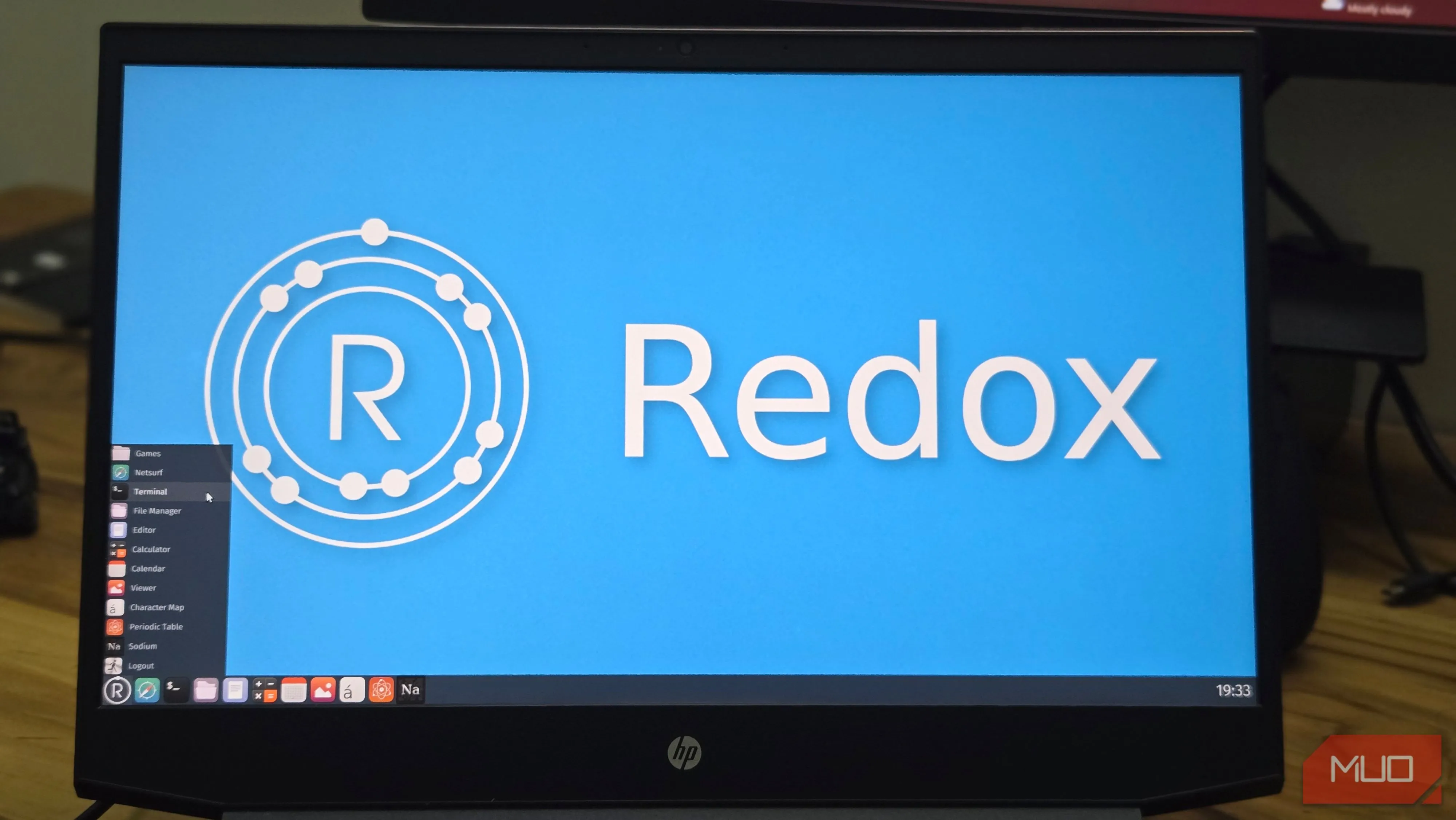 Redox OS chạy trên laptop HP, giao diện Orbital và bảng tuần hoàn biểu tượng dự án