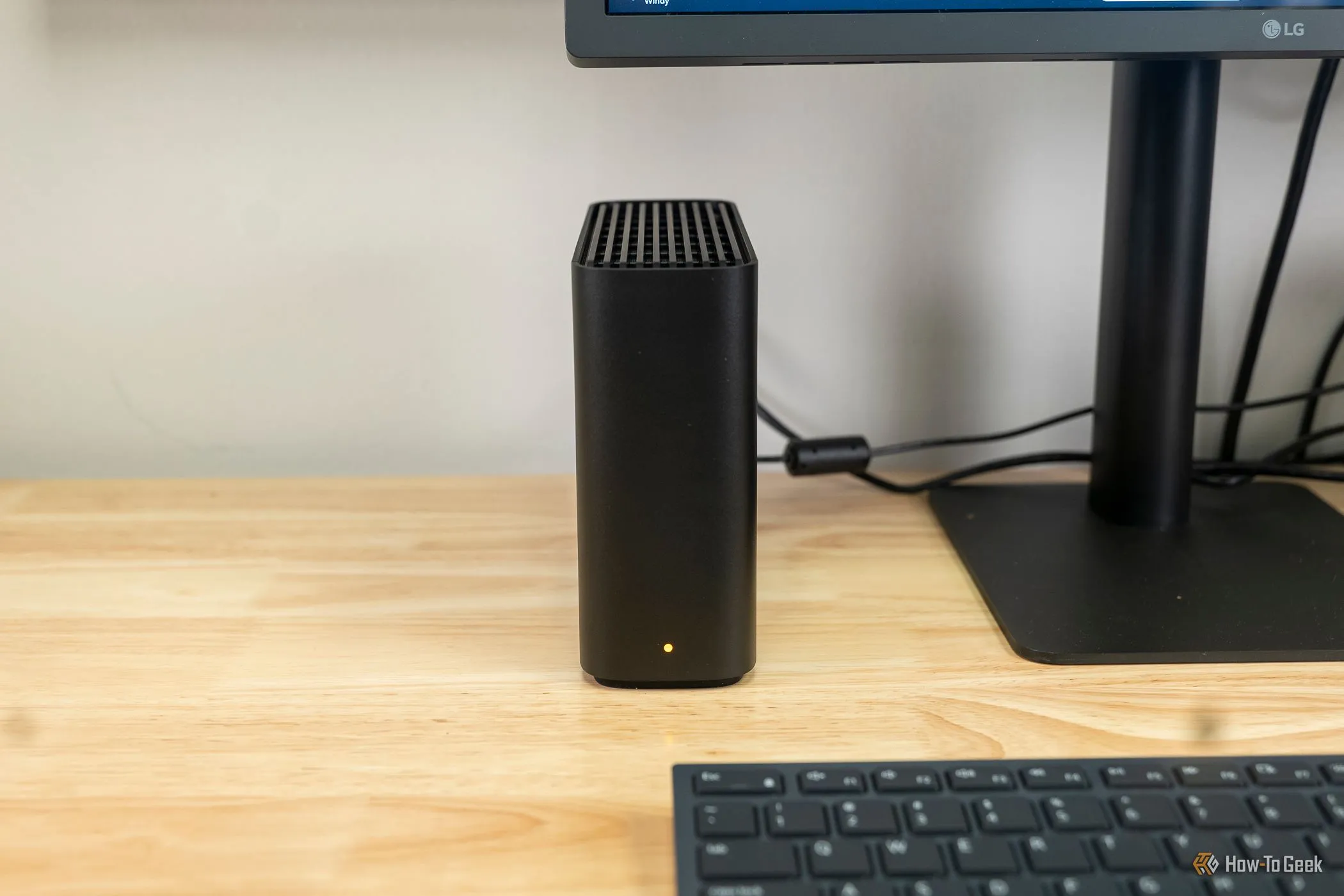 Thiết bị Synology BeeStation đặt bên cạnh màn hình, phù hợp làm máy chủ ảnh cá nhân cho cộng đồng game thủ