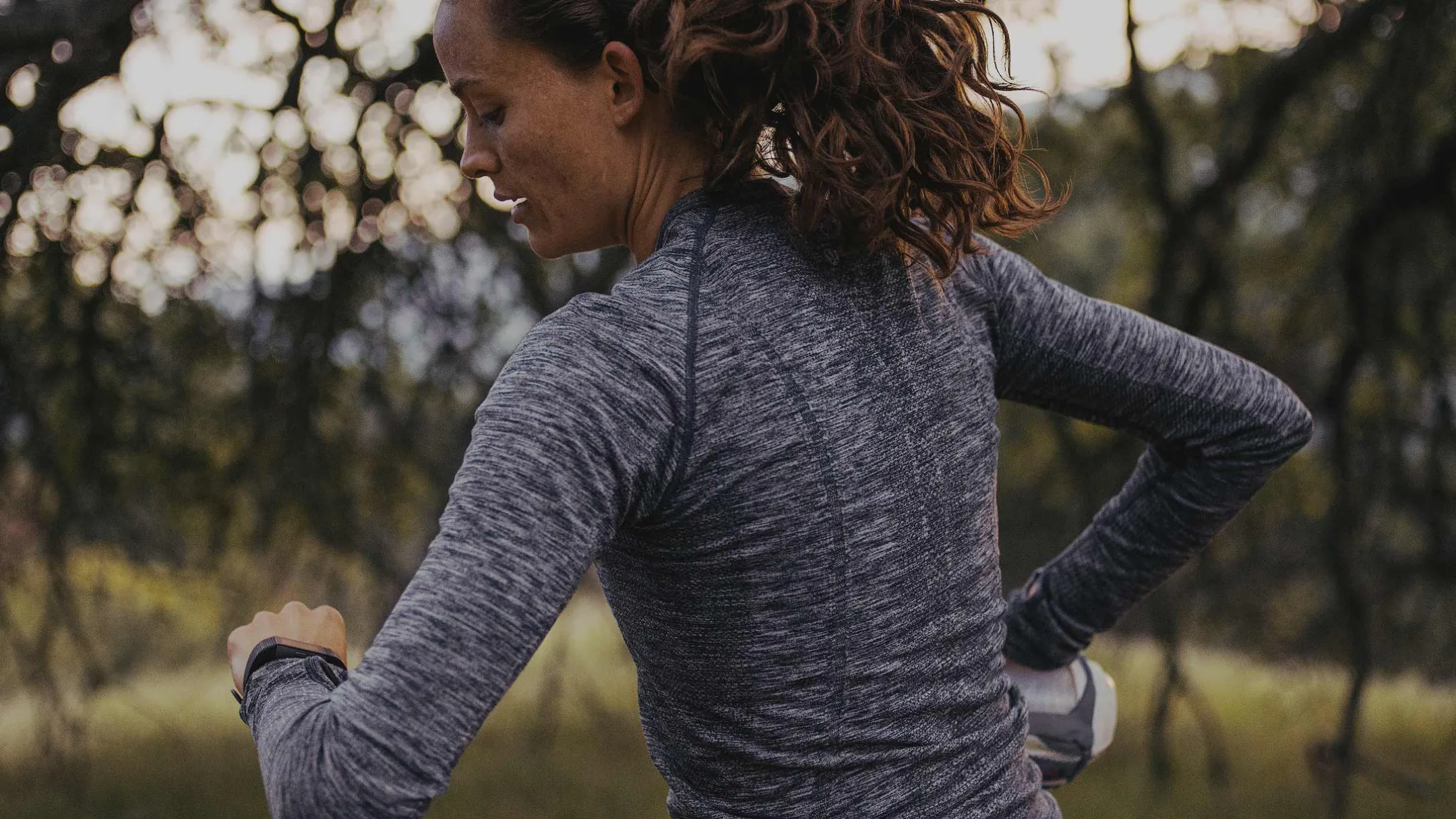 Vận động viên kiểm tra đồng hồ chạy bộ, minh họa mối liên hệ giữa thiết bị theo dõi và nền tảng dữ liệu